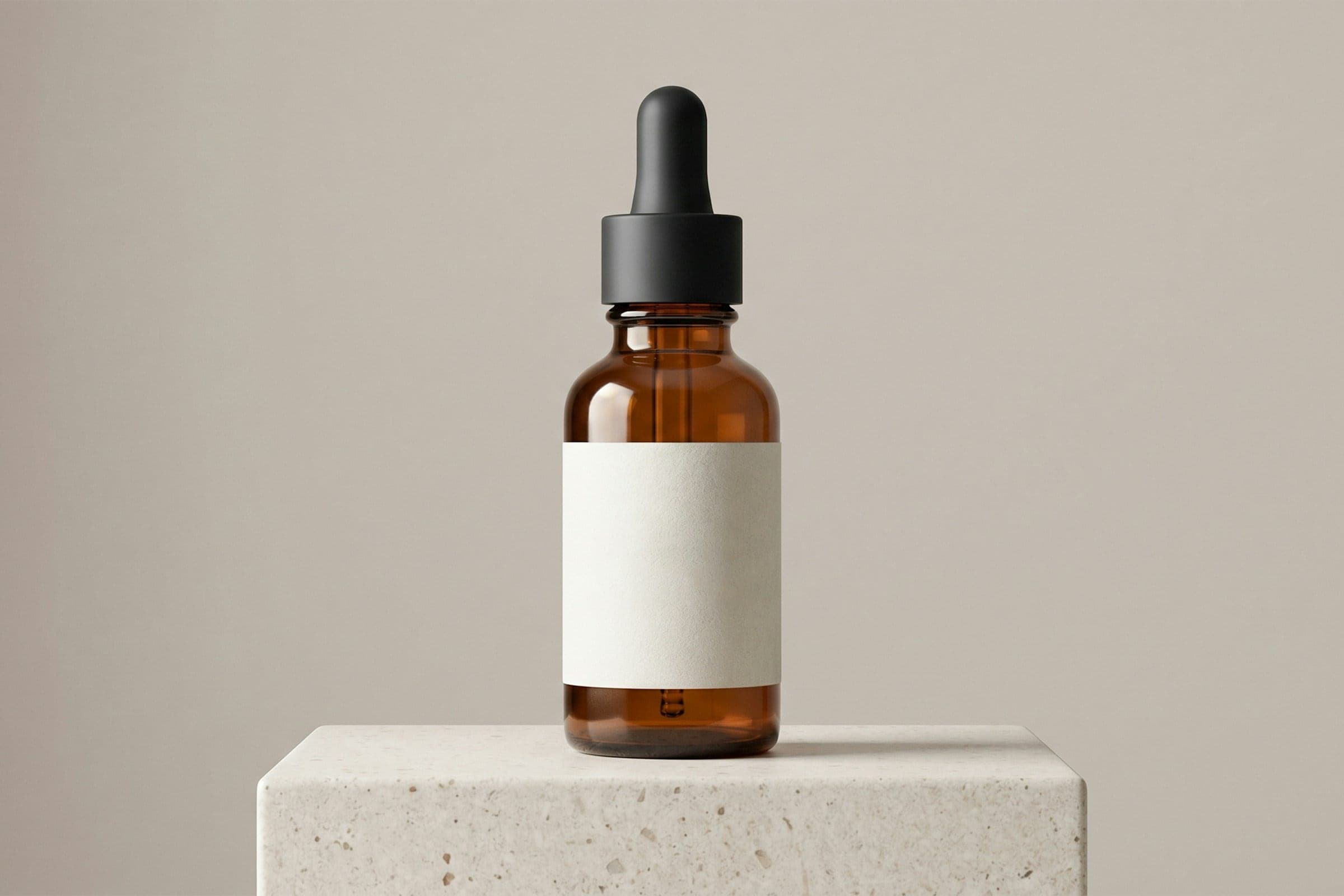 An amber dropper bottle on a stone plinth