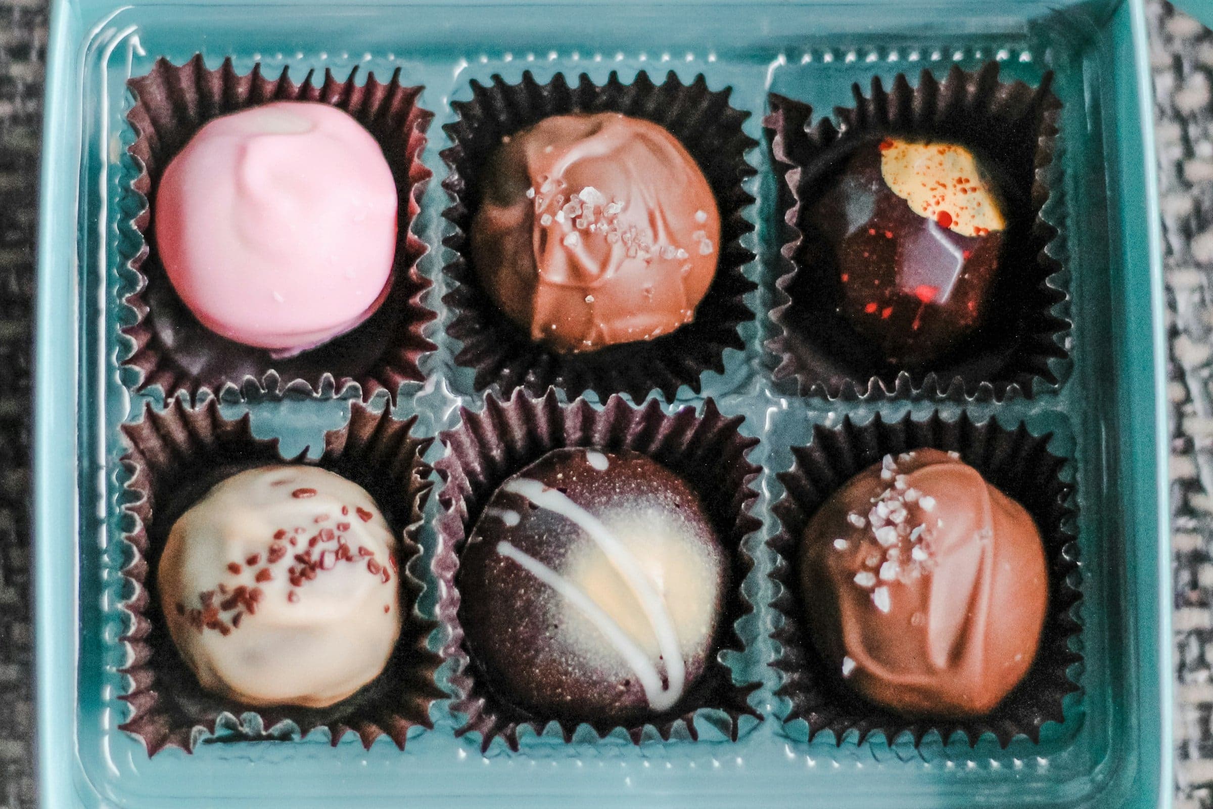 A box of six assorted chocolates, each in its own paper case