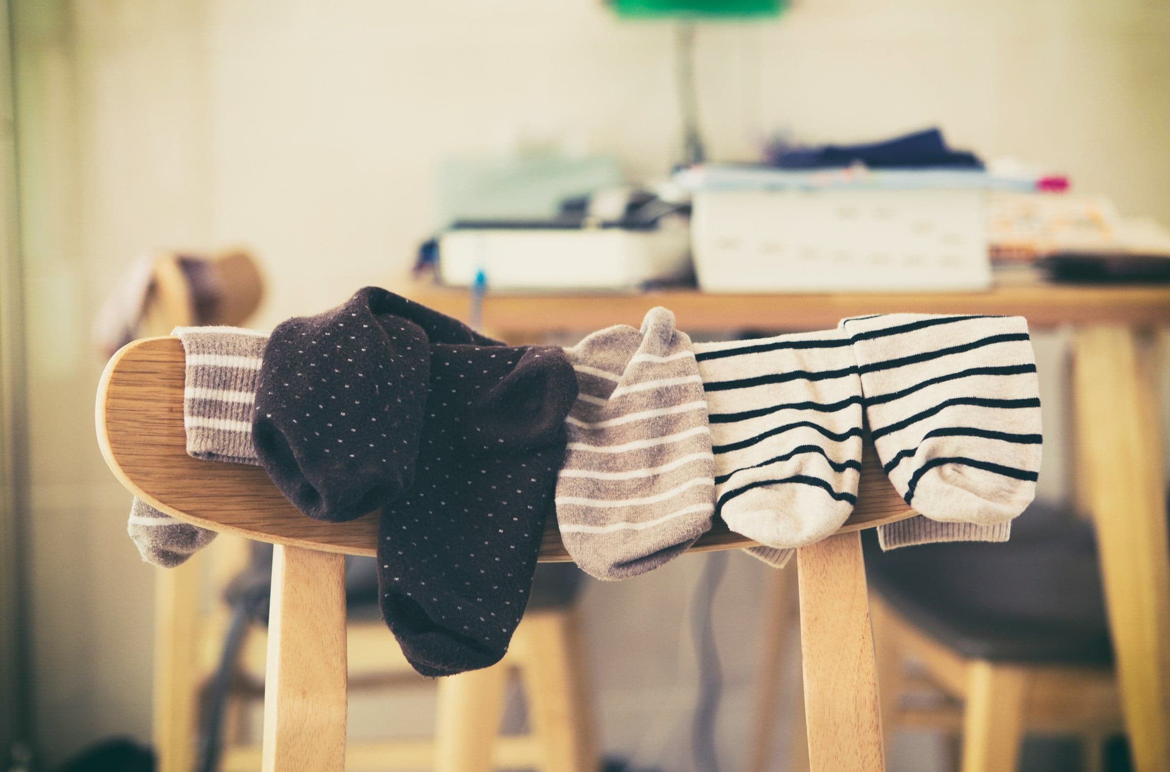 Pairs of patterned socks hung over the back of a wooden chair