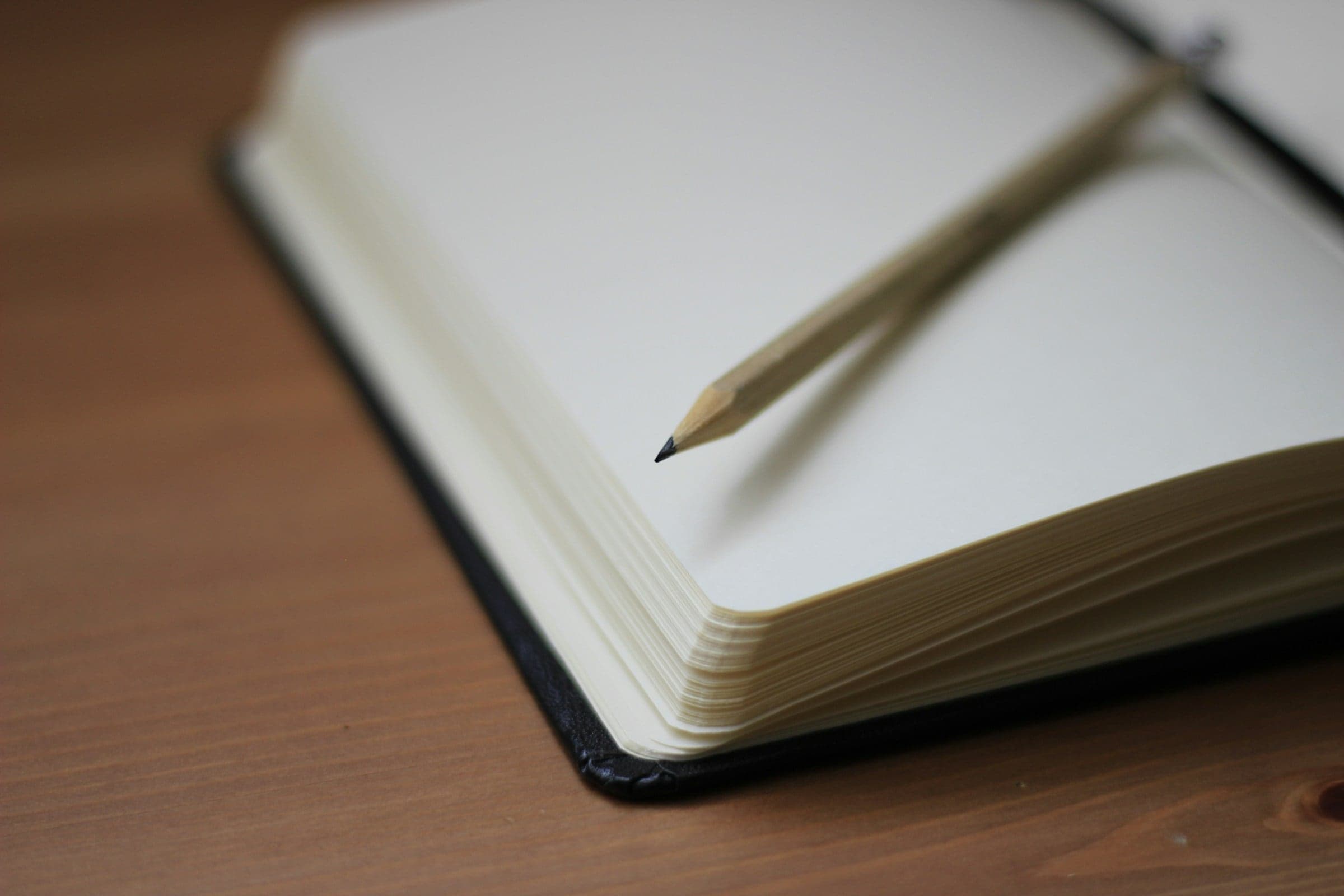 An open notebook with a pencil
