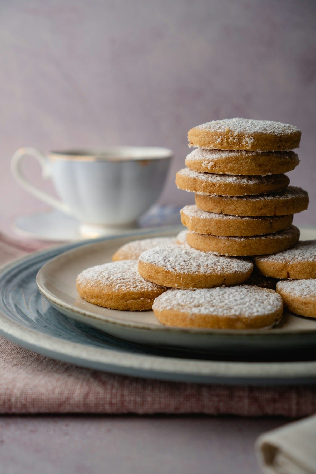 A stack of shortbread biscuits beside a teacup